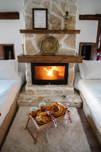 a living room with a fireplace and a table with food at la foret in Metsovo