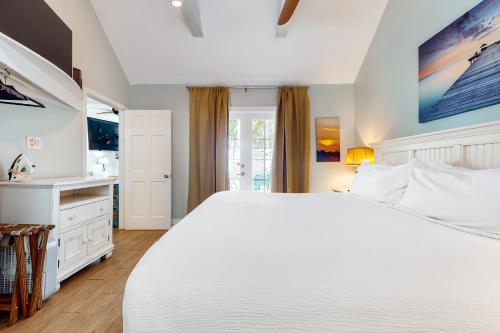 Un dormitorio blanco con una gran cama blanca. en Oceana Suite, en Key West