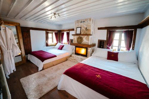 a bedroom with two beds with red and white sheets at la foret in Metsovo