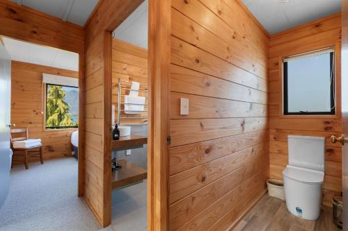 a bathroom with a toilet and wooden walls at Tranquil Heights in Queenstown