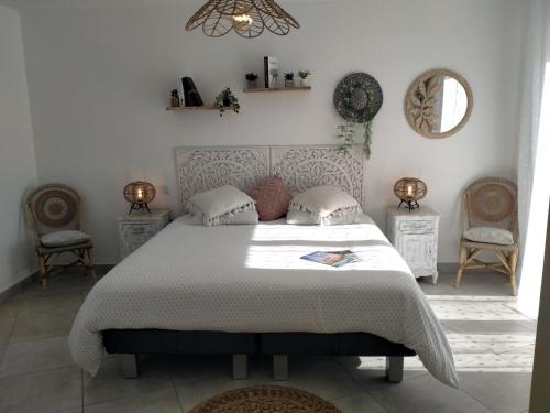 une chambre avec un grand lit et deux chaises dans l'établissement Villa de standing tout confort PISCINE climatisation, à Montauroux