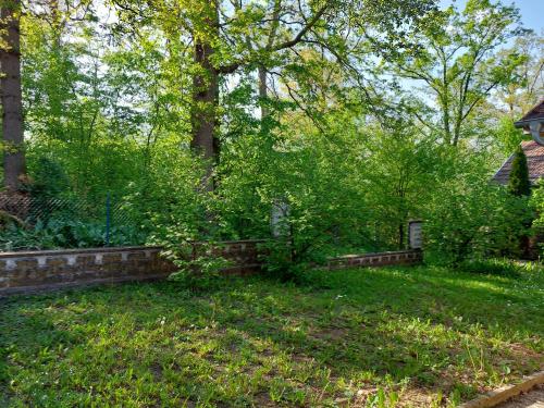 einen Garten mit Bäumen und einer Ziegelwand in der Unterkunft Cvrkut Ptica 1 in Mladenovac