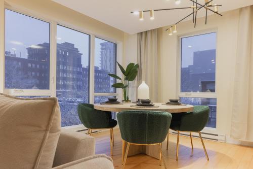 a living room with a table and chairs and windows at Rozenhaus Montreal Hotel in Montreal