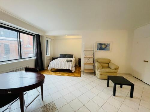 - un salon avec un lit et une chaise dans l'établissement Stylish Montreal Apartment: Comfortable Stay in the Golden Square Mile, à Montréal
