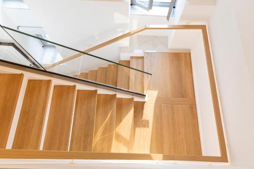 a glass staircase in a house with wooden floors at Maison 36 Villa in the center of Psyri in Athens