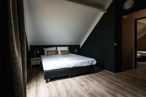 a bedroom with a bed with white sheets and two pillows at luxe vakantiehuisje - sauna - natuur - strand in Ewijk