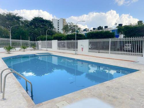 een blauw zwembad met een wit hek bij Apartaestudio Amoblado in Valledupar