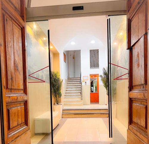 un corridoio con porta a vetri e scale di Hotel Sallustio a Roma