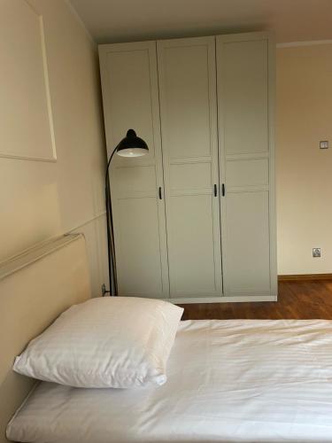 a bedroom with a bed with a lamp and a closet at Łukaszówki przy Krupówkach in Zakopane
