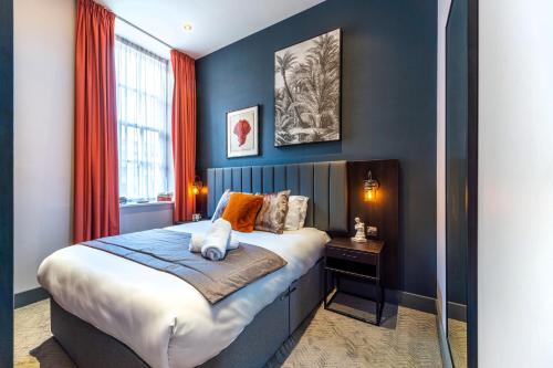 a bedroom with a large bed with blue walls at Duke Street Townhouse in Liverpool