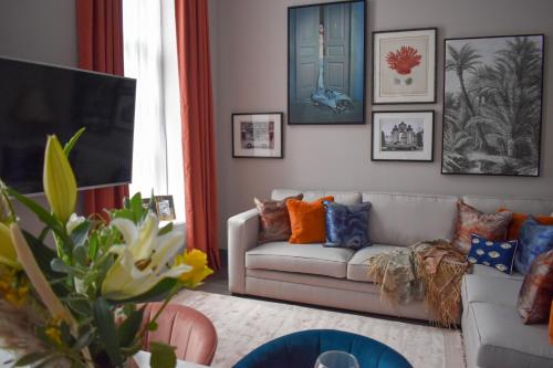 a living room with a couch and pictures on the wall at EPIC Duke Street Townhouse in Liverpool