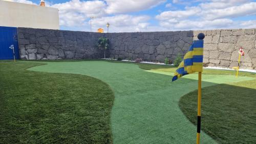 einen Golfplatz mit einer Haltewand und einer Flagge in der Unterkunft VV Mapaluca MiniGolf by HH in Playa Blanca