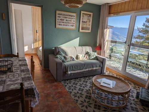 - un salon avec un canapé et une table dans l'établissement Charmant appartement centre ville de Font-Romeu, vue montagne, à Font-Romeu-Odeillo-Via