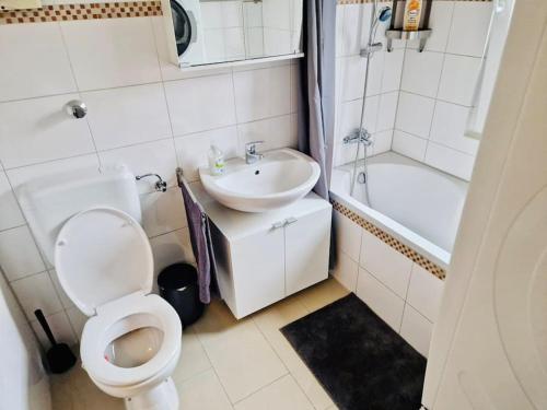 uma casa de banho branca com um WC e um lavatório em NEW-Berta die Kölner Vorstadtwohnung em Bergheim