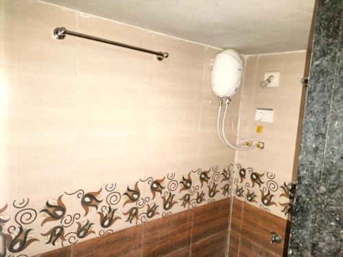 La salle de bains est pourvue d'une douche murale. dans l'établissement Ashapura Home Stay, à Kevadia