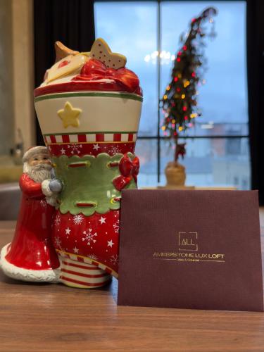 a santa claus figurine sitting next to a sign at ALL - Amberstone Lux Loft in Klaipėda