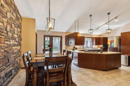 a large kitchen with a table and a stone wall at Great Group Getaway: Games Galore + Outdoor Oasis in Painesville