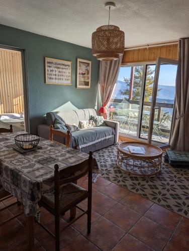 un salon avec un canapé et une table dans l'établissement Charmant appartement centre ville de Font-Romeu, vue montagne, à Font-Romeu-Odeillo-Via