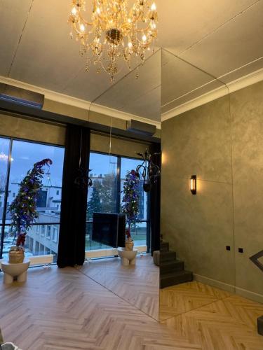 a large living room with a chandelier and a staircase at ALL - Amberstone Lux Loft in Klaipėda