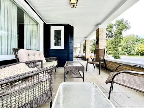 a porch with wicker chairs and a table on a house at 19th Century 'Cleveland Double' - Walk To Beach in Cleveland