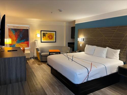 una habitación de hotel con una cama grande y una silla en La Quinta by Wyndham OKC North - Quail Springs, en Oklahoma City