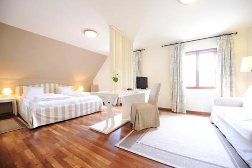 um quarto com 2 camas, uma secretária e um sofá em Renaissancehotel Raffelsberger Hof B&B em Weissenkirchen in der Wachau