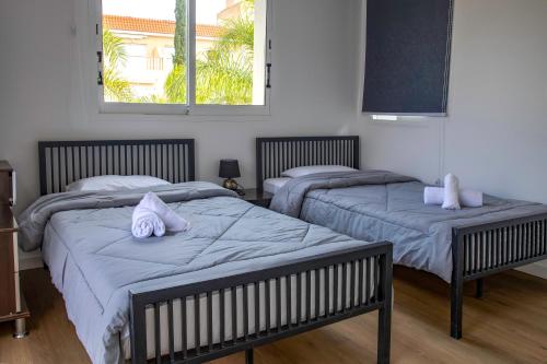 - une chambre avec 2 lits et des serviettes dans l'établissement Villa Myria, à Paphos