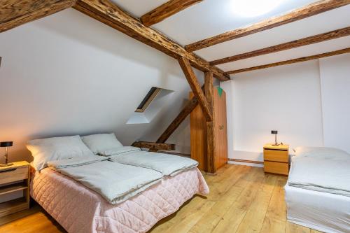 2 Betten in einem Zimmer mit Holzbalken in der Unterkunft Apartmán u Ljuby in Jáchymov
