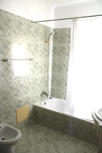 a bathroom with a tub and a toilet and a sink at Moradia Bela House in Santa Cruz
