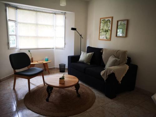 a living room with a black couch and a table at CASA BOUTIQUE ESQUEL in Esquel