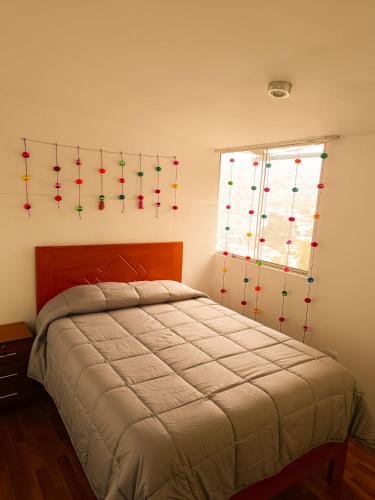 a bedroom with a bed with christmas lights on the wall at Apartamento Mirador San Blas in Cusco