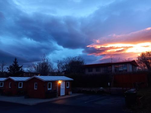 a house with a sunset in the background at The Castle in Búðardalur