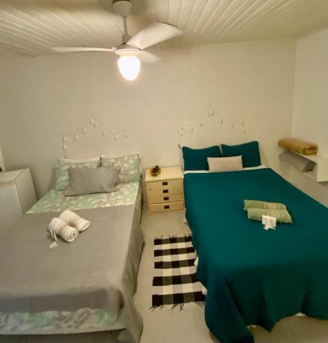 a bedroom with two beds and a ceiling fan at SUÍTES Caminho do Mar in Abraão