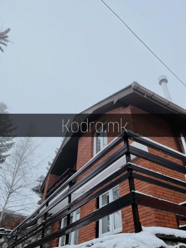 a brick house with a black roof in the snow at Kodra - Villa 71 in Tetovo