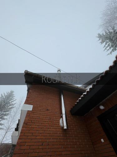 um sinal na lateral de um edifício de tijolos em Kodra - Villa 71 em Tetovo