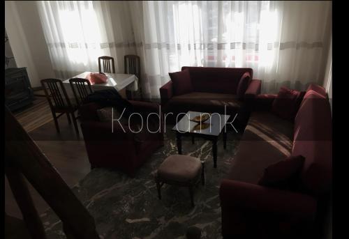 salon z czerwonymi kanapami i stołem w obiekcie Kodra - Villa 71 w mieście Tetowo