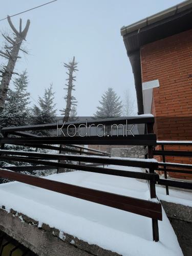 eine schneebedeckte Bank neben einem Gebäude in der Unterkunft Kodra - Villa 71 in Tetovo