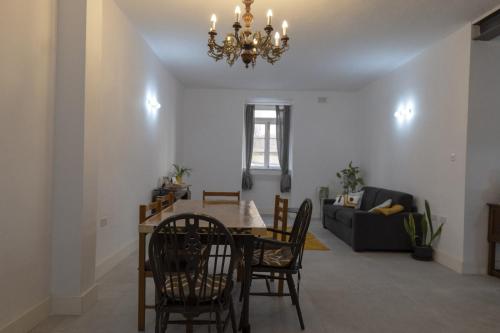 a dining room and living room with a chandelier at Green door Valletta in Valletta