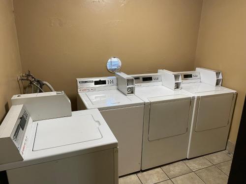 a laundry room with three washing machines and a counter at Valley Motel El Cajon San Diego in El Cajon