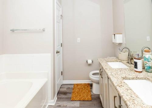 a bathroom with two sinks and a shower at Beach Home w Peloton & Pool & Billiards in Raleigh