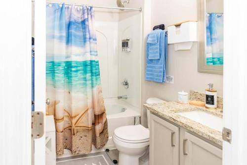 a bathroom with a toilet and a sink and a shower at Beach Home w Peloton & Pool & Billiards in Raleigh