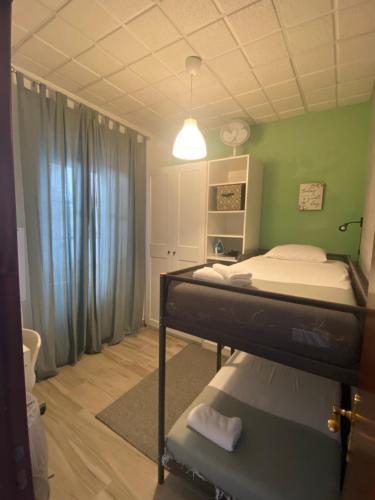 a bedroom with a bunk bed and a green wall at Beato Typical House in Lisbon