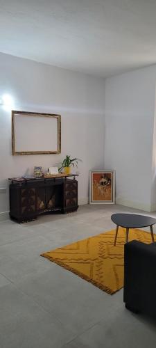 - un salon avec une table et un tapis jaune dans l'établissement Green door Valletta, à La Valette