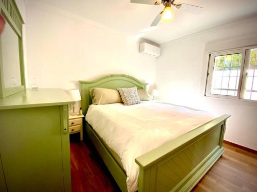 a bedroom with a green bed and a window at MyChoice Villa Almadraba in Rota