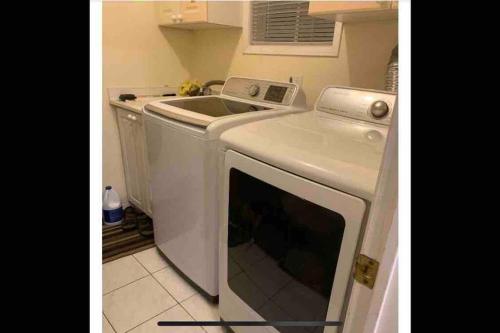 a kitchen with a washing machine and a sink at Large Separate Entrance Basement Unit 2Beds 1Washroom Sleeps 4-6 in Pickering