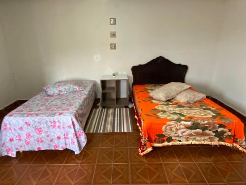 um quarto com duas camas e uma mesa de cabeceira em Casa Gaita - Temporada em Triunfo