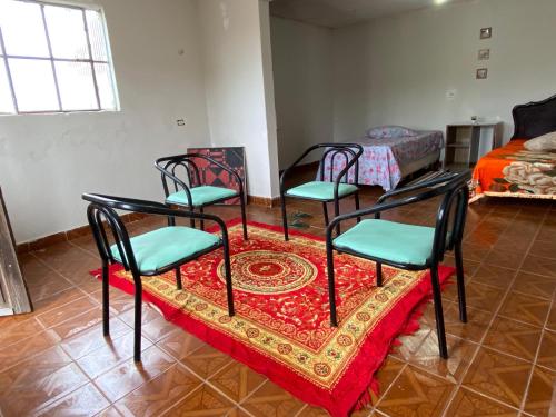 um quarto com quatro cadeiras e uma mesa com um tapete em Casa Gaita - Temporada em Triunfo