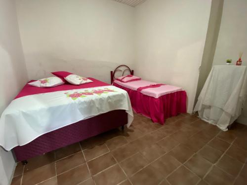 a room with two beds and a table in it at Casa Gaita - Temporada in Triunfo