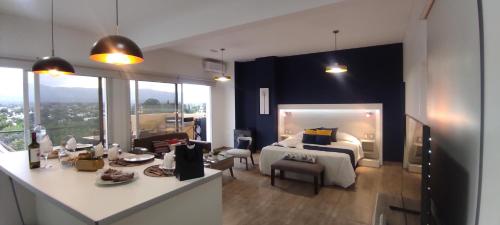 1 dormitorio con cama extragrande y mesa en Amanecer apartamentos en Luján de Cuyo