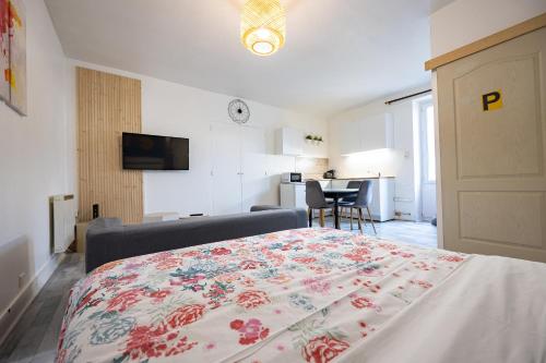 - une chambre avec un lit doté d'une couverture fleurie dans l'établissement LE STUDIO DE L'ILE, à Nantes